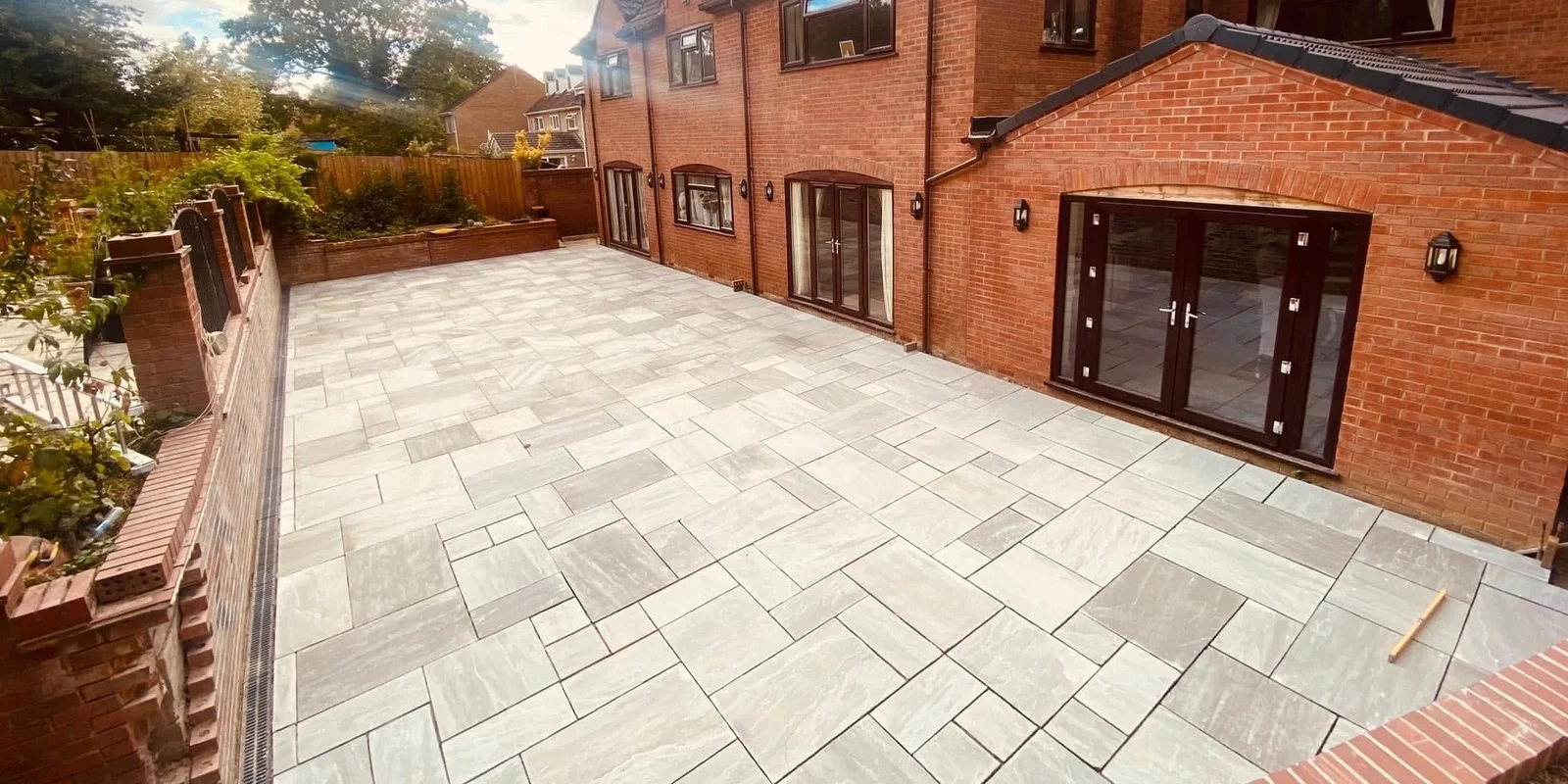 Newly completed grey porcelain patio with block-paved edging at a Peterborough property